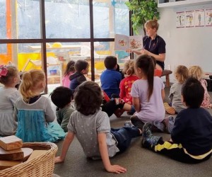 A teacher reading a book to a group of children
